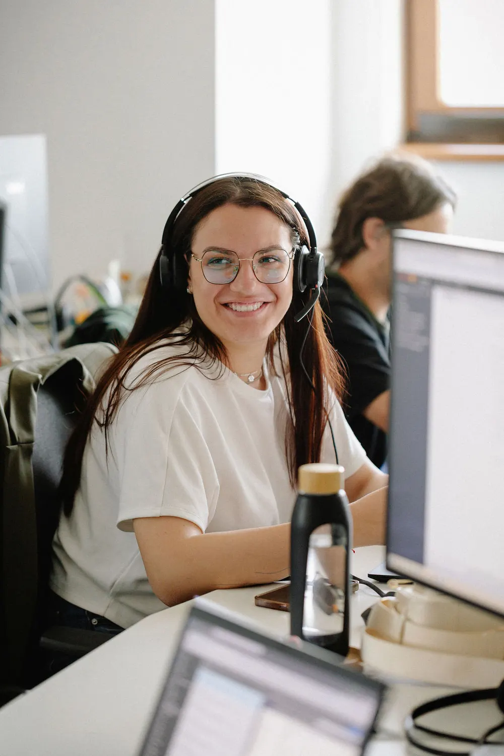 A consultant with a headset at her monitors